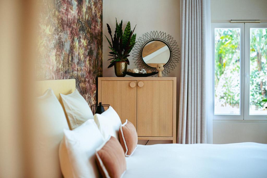 a bedroom with a bed with a mirror and a window at Boutique Hôtel Villa Fabulite in Antibes