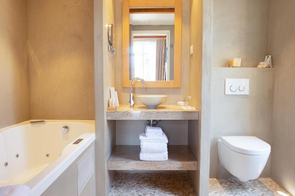 a bathroom with a tub and a sink and a toilet at Boutique Hôtel Villa Fabulite in Antibes