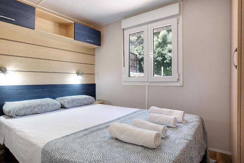 een slaapkamer met een bed met twee handdoeken erop bij Mobile Home Maria Marta in Barbate