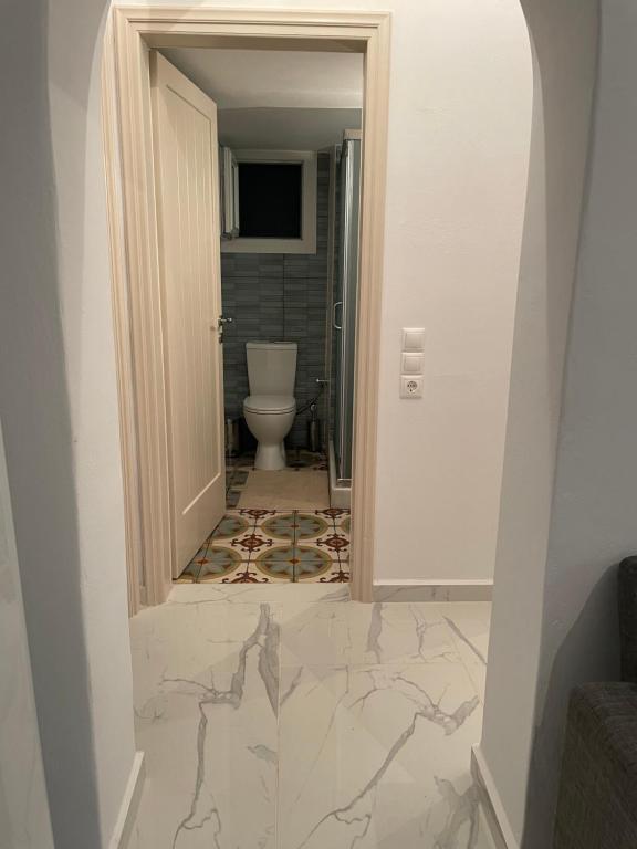 a corridor of a bathroom with a toilet and a doorway at Diakofti house by the sea - Kythoikies hoilday houses in Kythira