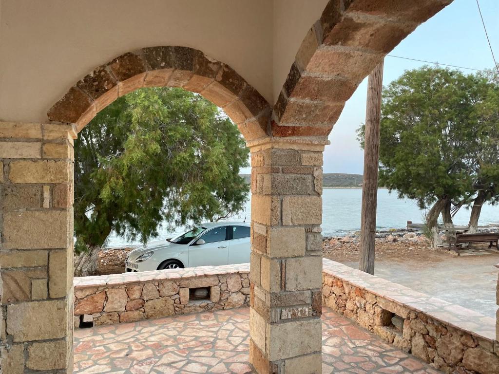 an archway in a building with a car in the background at Diakofti house by the sea - Kythoikies hoilday houses in Kythira