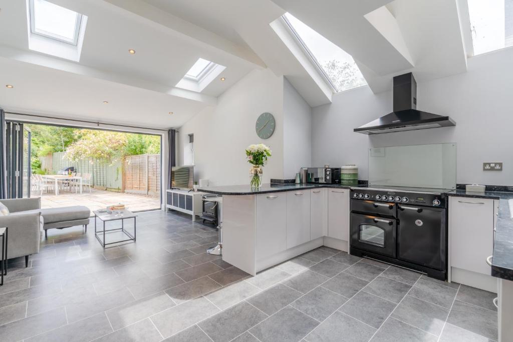 a kitchen with a stove and a living room at Otley House in Cheltenham