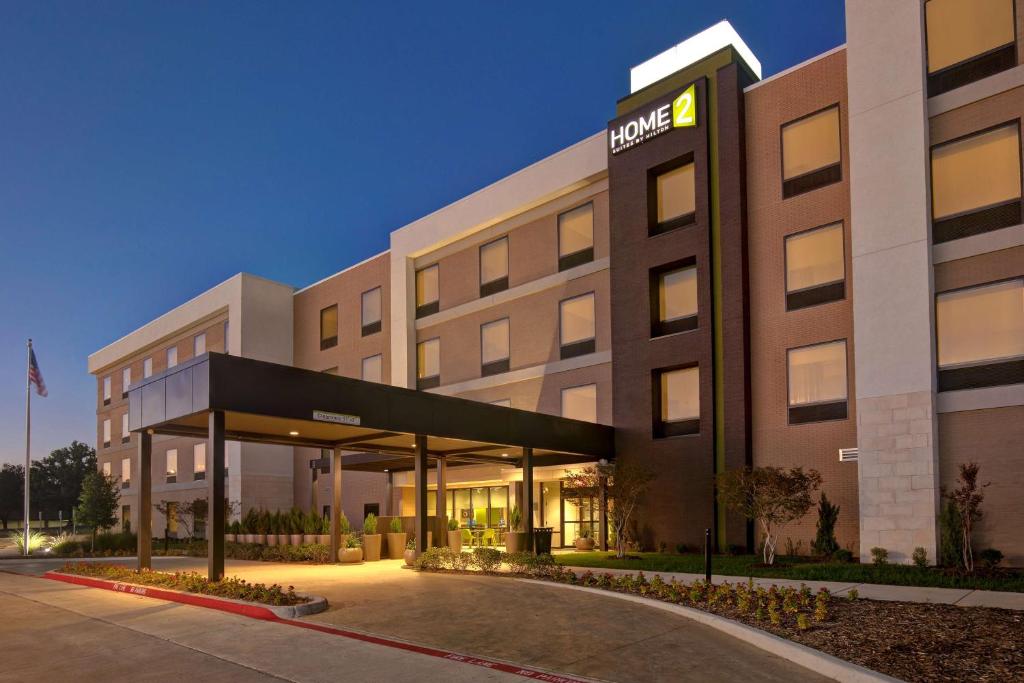 a hotel building with a sign on the front of it at Home2 Suites By Hilton Lewisville Dallas in Lewisville