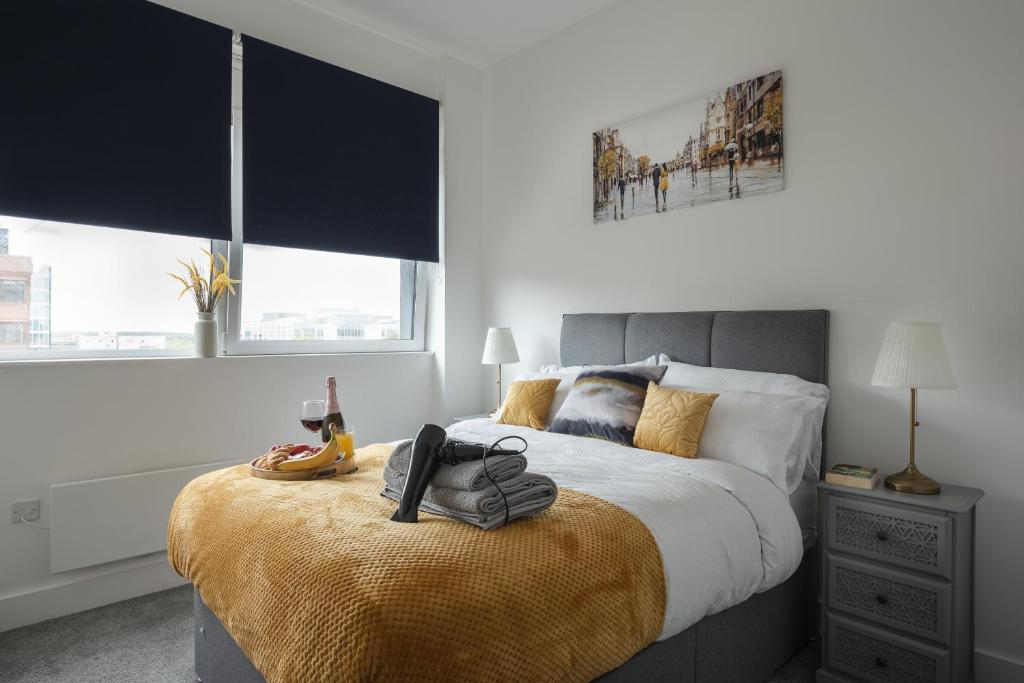 a bedroom with a large bed with shoes on it at Deluxe 2 bed, 2 bathroom Milton Keynes apartment within walking distance to train station and City centre. in Milton Keynes