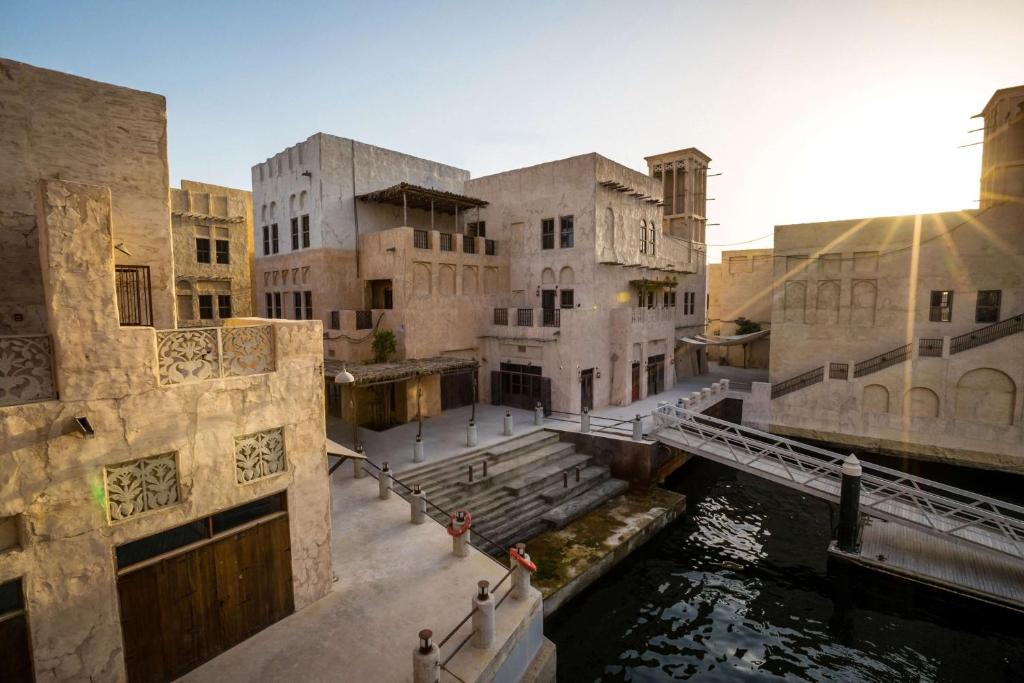 ドバイにあるAl Seef Heritage Hotel Dubai, Curio Collection by Hiltonの運河の隣の一団