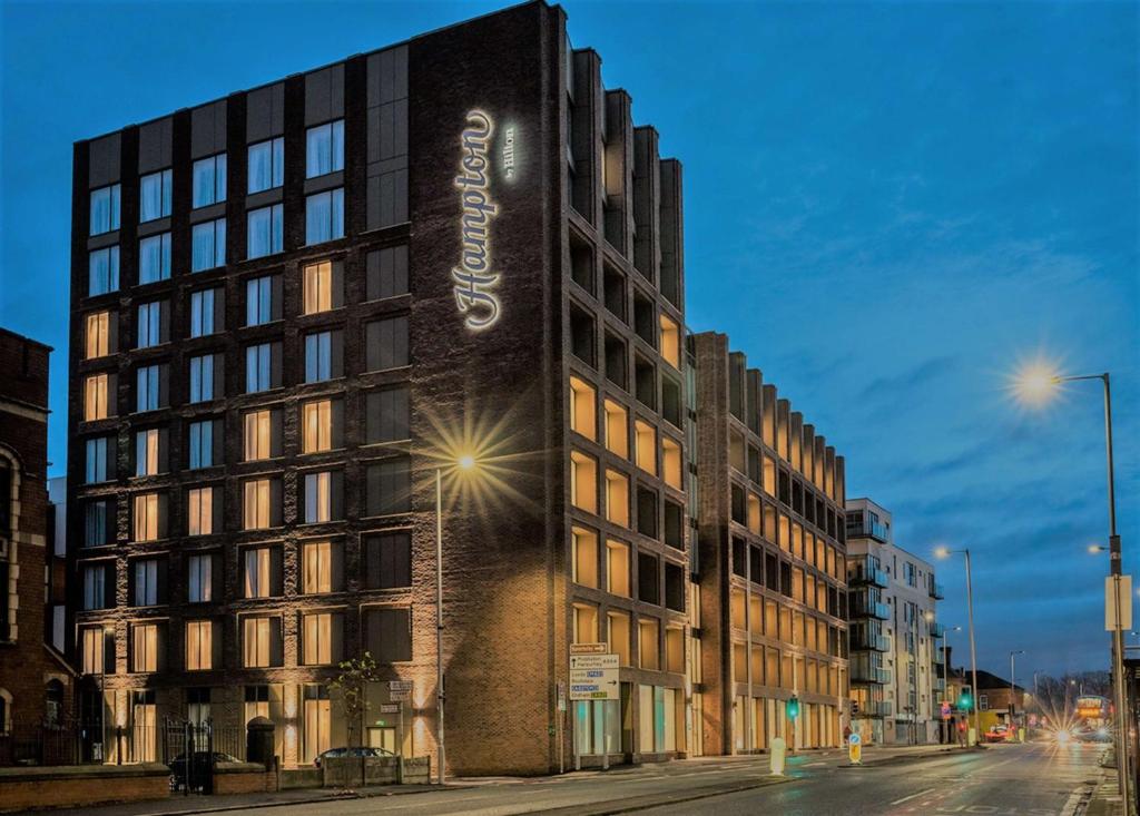 a building with a sign on the side of it at Hampton By Hilton Manchester Northern Quarter in Manchester