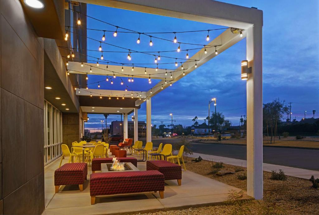 d'une terrasse avec une table, des chaises et des lumières. dans l'établissement Home2 Suites By Hilton Yuma Pivot Point, à Yuma