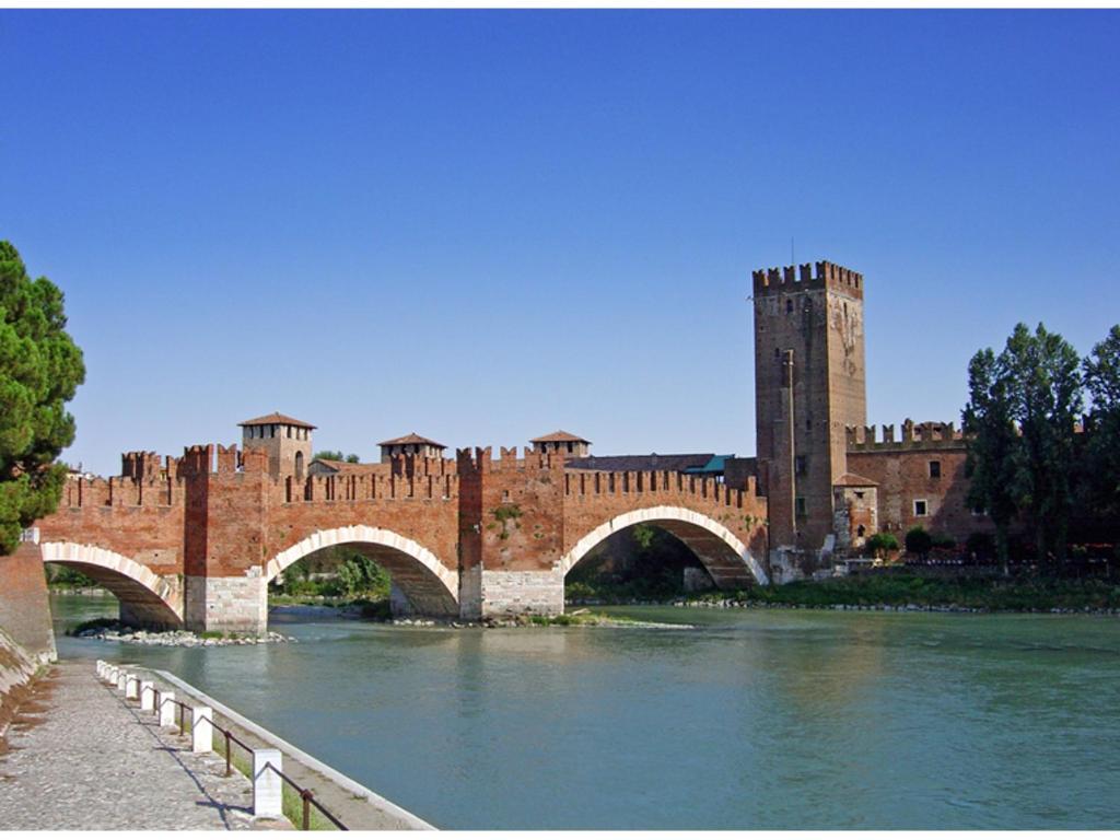 un gran edificio de ladrillo con un puente sobre un río en Castle View - Apartment, en Verona