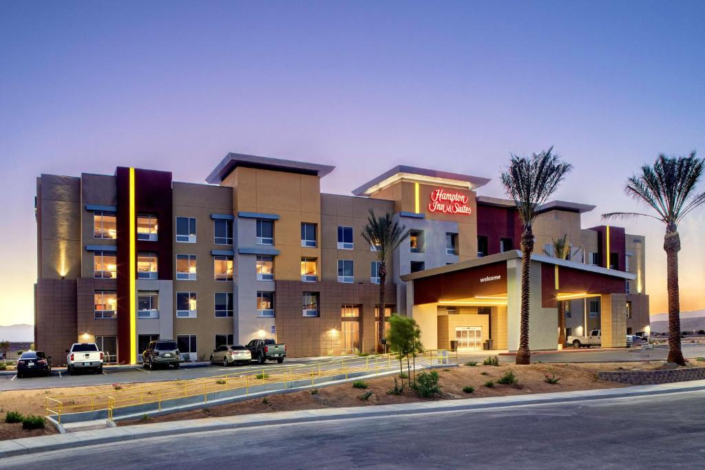 a hotel with palm trees in front of a building at Hampton Inn & Suites Indio, Ca in Indio