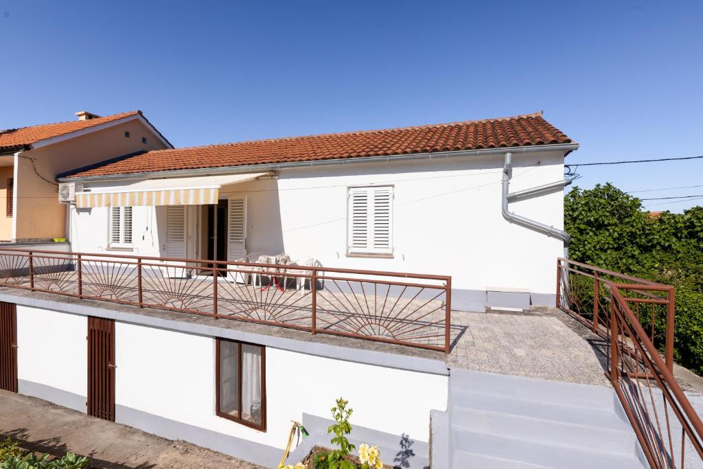 a white house with a balcony with a deck at Apartment Dunato in Polje