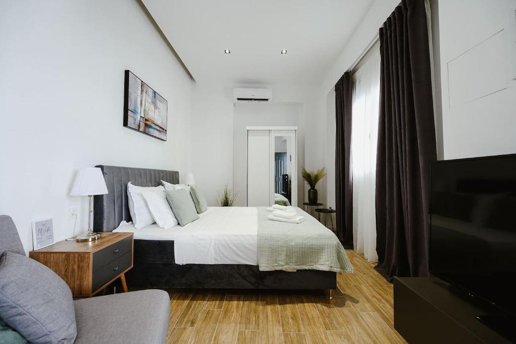 a bedroom with a bed and a couch and a tv at M & N Guesthouse in Volos