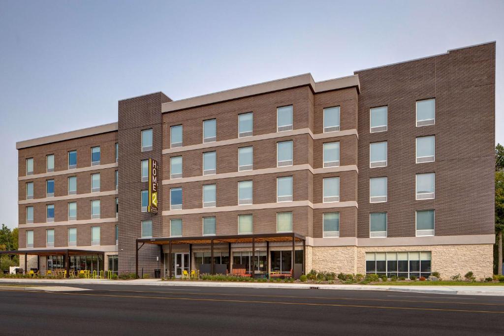 a large brick building on the side of a street at Home2 Suites By Hilton Carmel Indianapolis in Carmel