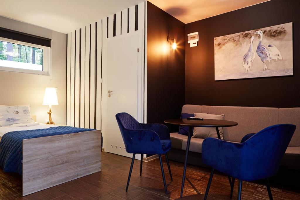 a bedroom with a bed and a table and chairs at Ośrodek Wypoczynkowy Nad Zatoką in Koronowo
