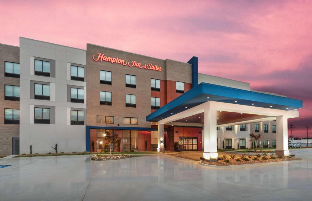 a hotel with a building with a sign on it at Hampton Inn & Suites Conway, Ar in Conway