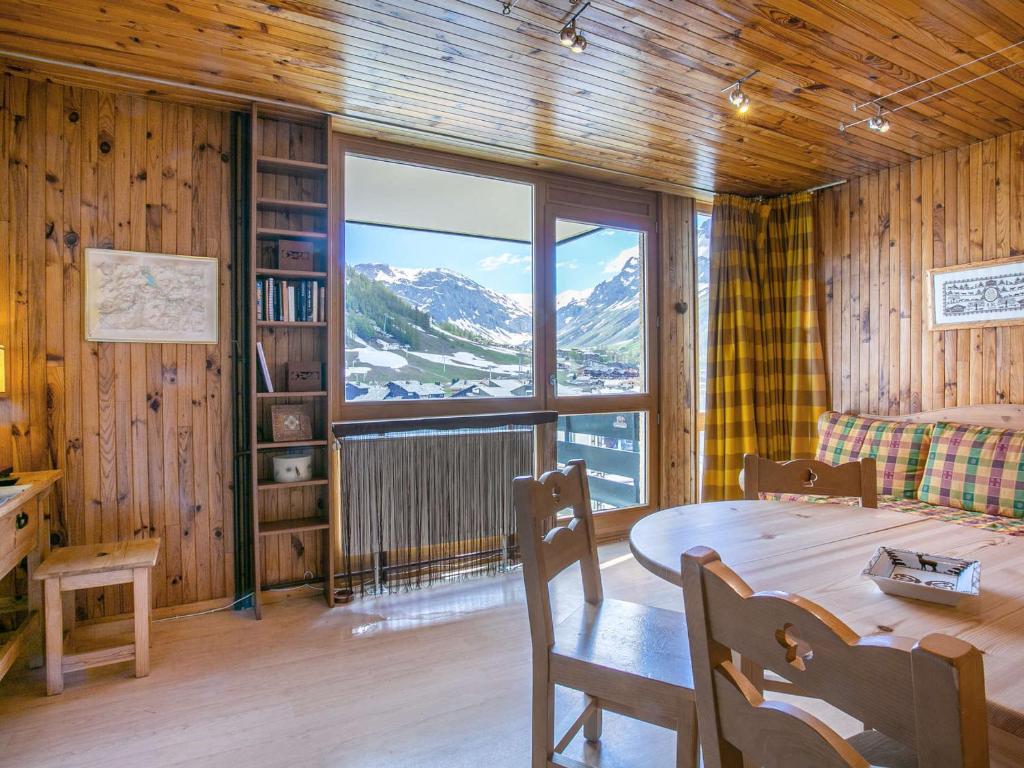 une salle à manger avec une table et une grande fenêtre dans l'établissement Charmant appartement 2 pièces avec balcon, cuisine équipée et belles vues - 5 pers - FR-1-694-195, à Val dʼIsère