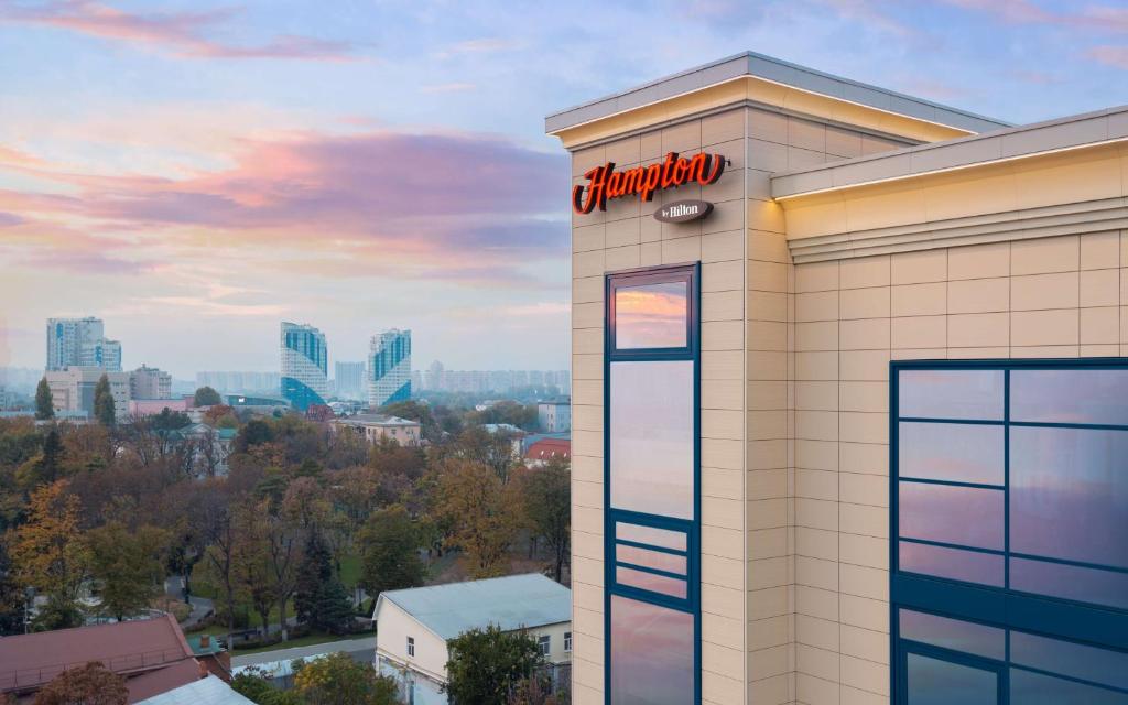 un bâtiment chrysler avec un panneau sur celui-ci dans l'établissement Hampton By Hilton Krasnodar, à Krasnodar