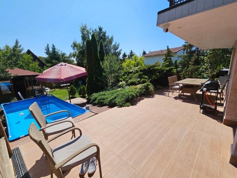 eine Terrasse mit Stühlen und einem Pool in der Unterkunft Leśne Apartamenty in Hel