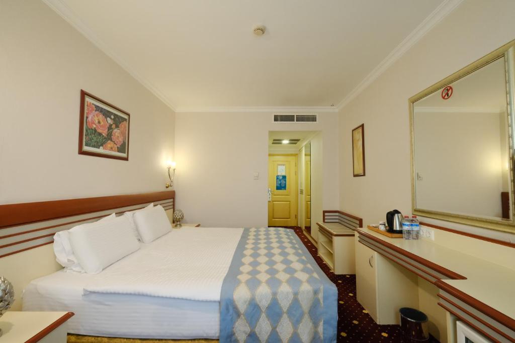 a hotel room with a bed and a mirror at Akar International Hotel in Ankara