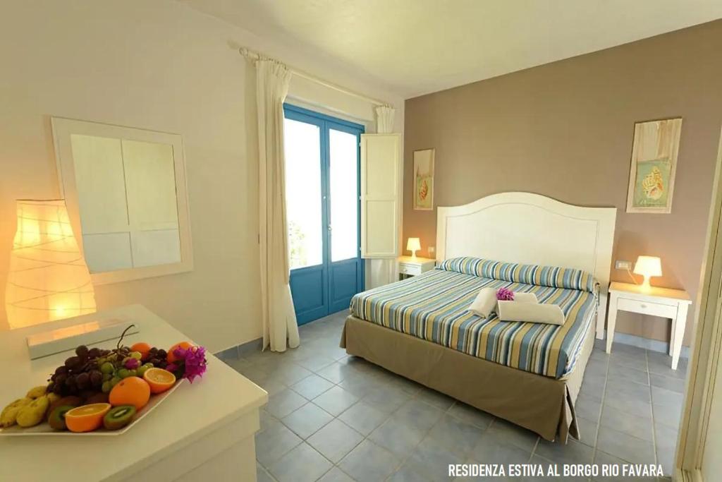 Residenza estiva al Borgo Rio Favara في سانتا ماريا ديل فوكالو: غرفة نوم بسرير وطاولة مع صحن من الفواكه