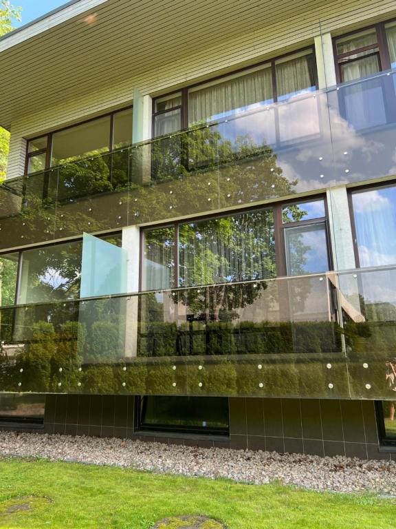 a building with a glass facade with plants at Sausoji Apartment in Druskininkai