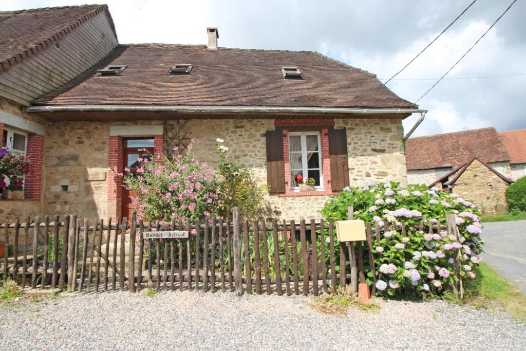 a house with a fence and flowers in front of it at Hamlet retreat in Ladignac-le-Long