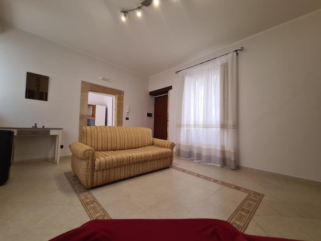 a living room with a couch and a window at Casa Igea in Siracusa