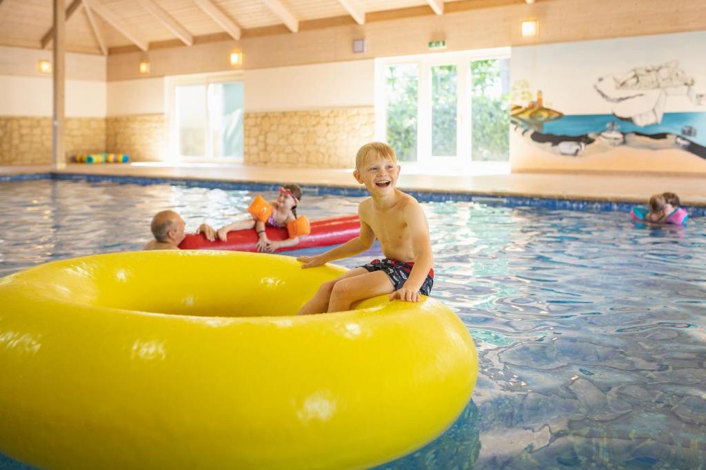 a young boy sitting on a raft in a pool at Camping Marvilla Parks Friese Meren - Roan in Wijckel