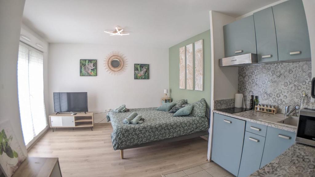 a living room with a bed and a kitchen at MENTHE et CITRON entre DISNEY et PARIS in Villiers-sur-Marne