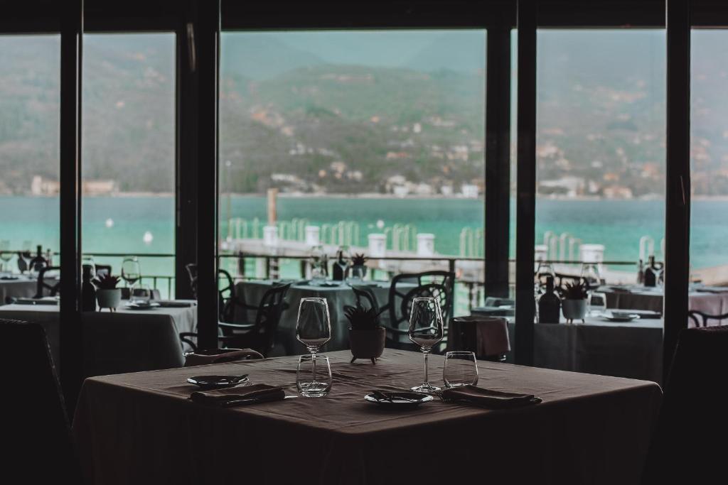 een tafel in een restaurant met uitzicht op de oceaan bij Bella Hotel & Restaurant with private dock for mooring boats in San Felice del Benaco