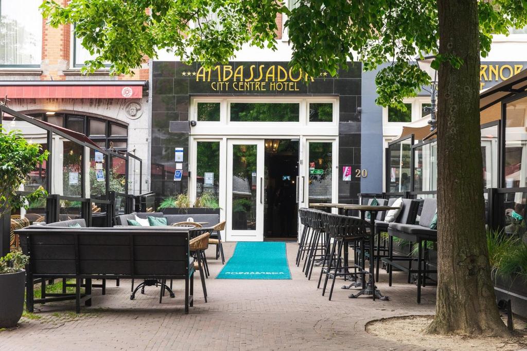 an empty patio with tables and chairs in front of a restaurant at Ambassador City Centre Hotel in Haarlem