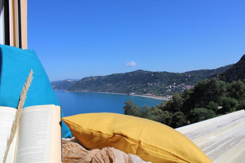 a book sitting on a bed with a view of a lake at Artistic Sea View House in Corfu