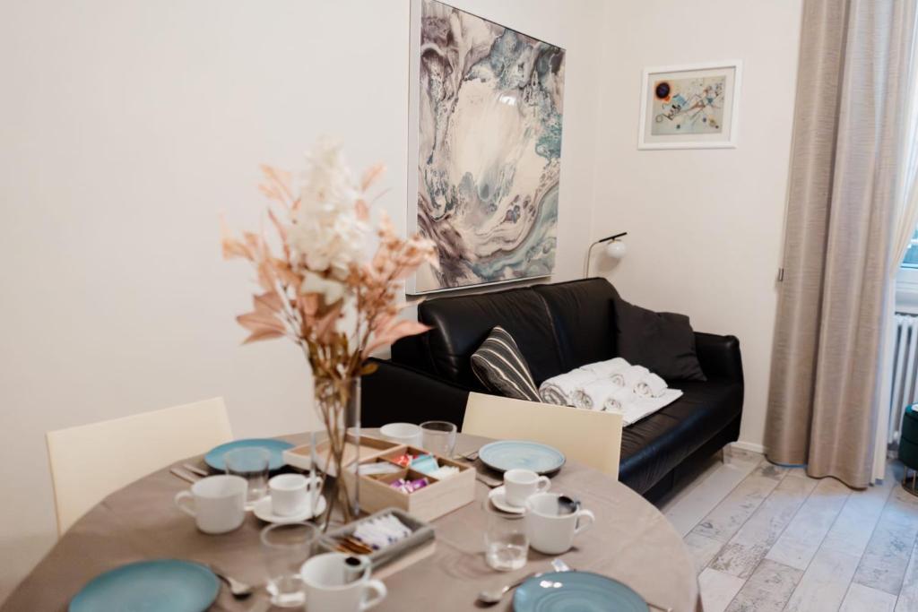 a living room with a table and a black couch at La casetta del SI minore in Bari