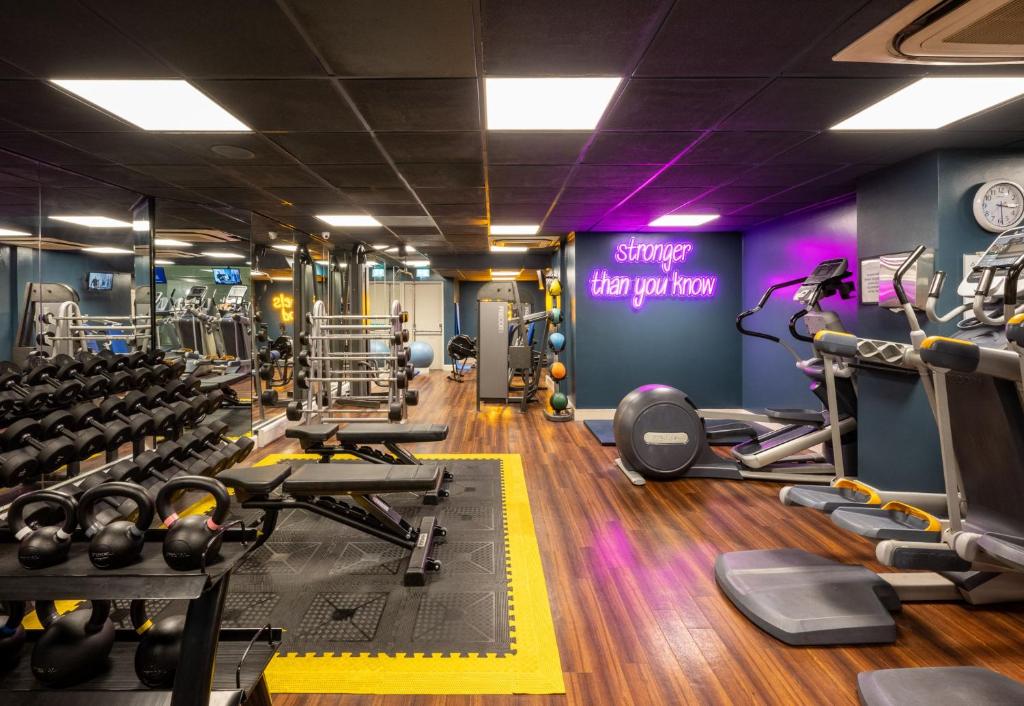 a gym with lots of machines and a sign that reads stronger than opinion at Leonardo Royal Hotel Brighton Waterfront in Brighton & Hove
