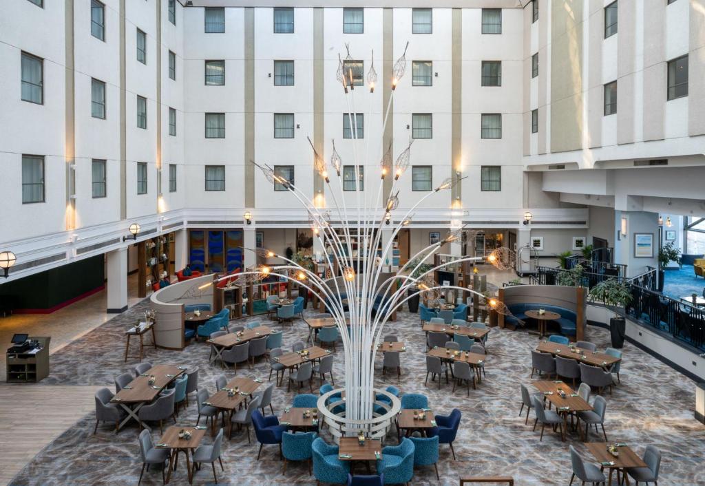 a view of therium of a hotel with tables and chairs at Leonardo Royal Hotel Brighton Waterfront in Brighton & Hove