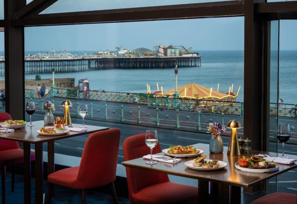 a restaurant with two tables and a view of the ocean at Leonardo Royal Hotel Brighton Waterfront in Brighton & Hove