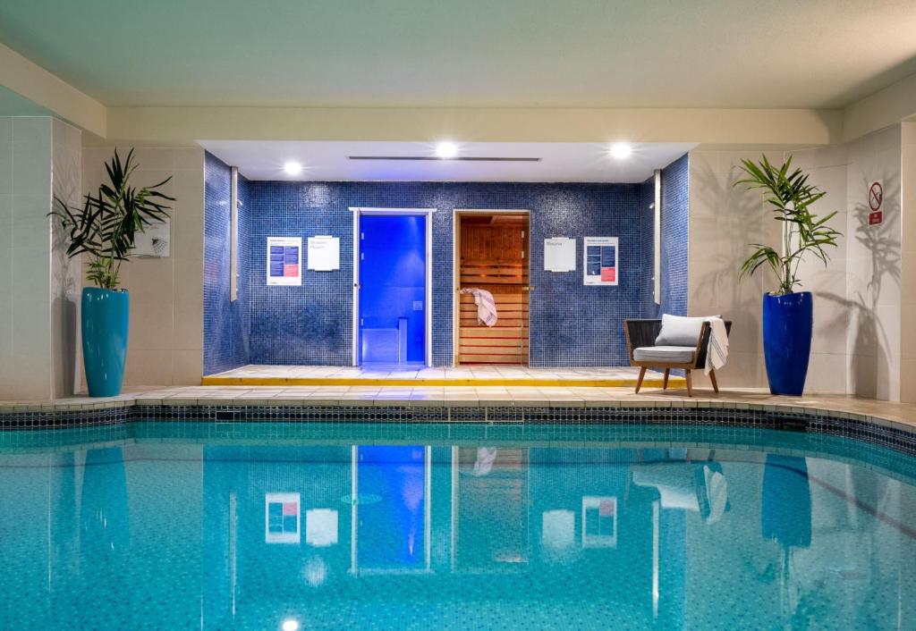 a swimming pool with a chair next to a house at Leonardo Royal Hotel Brighton Waterfront in Brighton & Hove