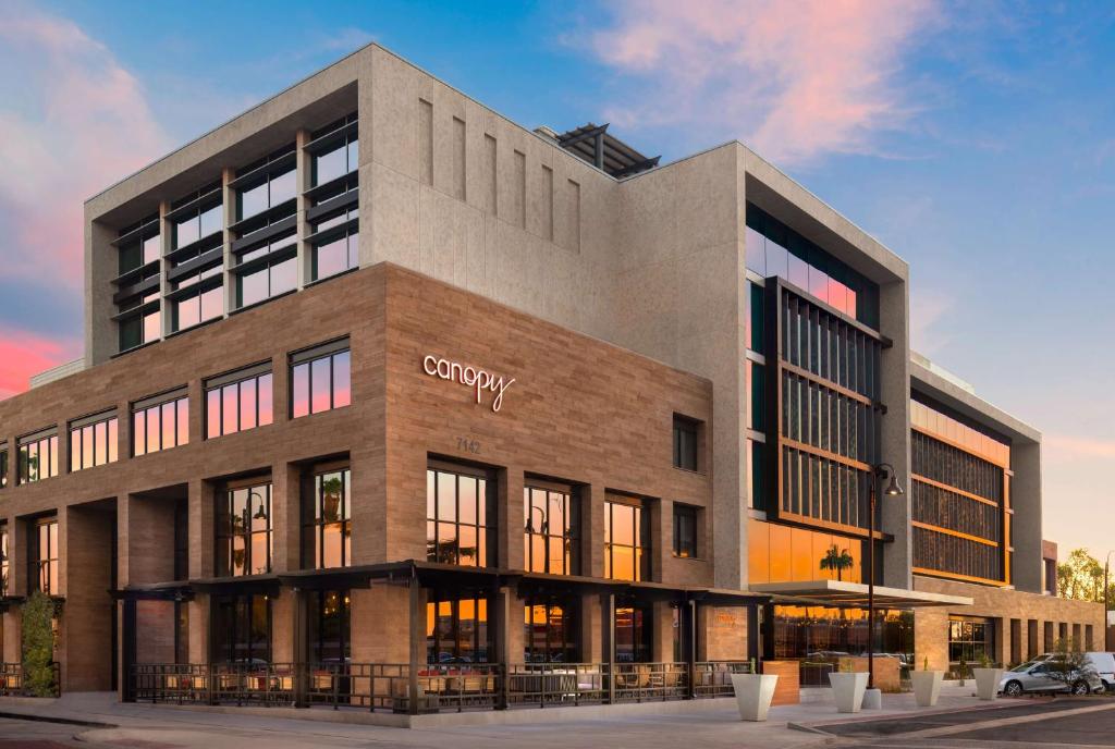 a large building with a company sign on it at Canopy By Hilton Scottsdale Old Town in Scottsdale