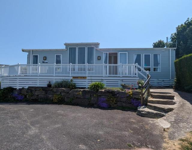 a large white house with a porch and a fence at Caravan Swanage Bay View Holiday Park Dorset Amazing Location in Swanage