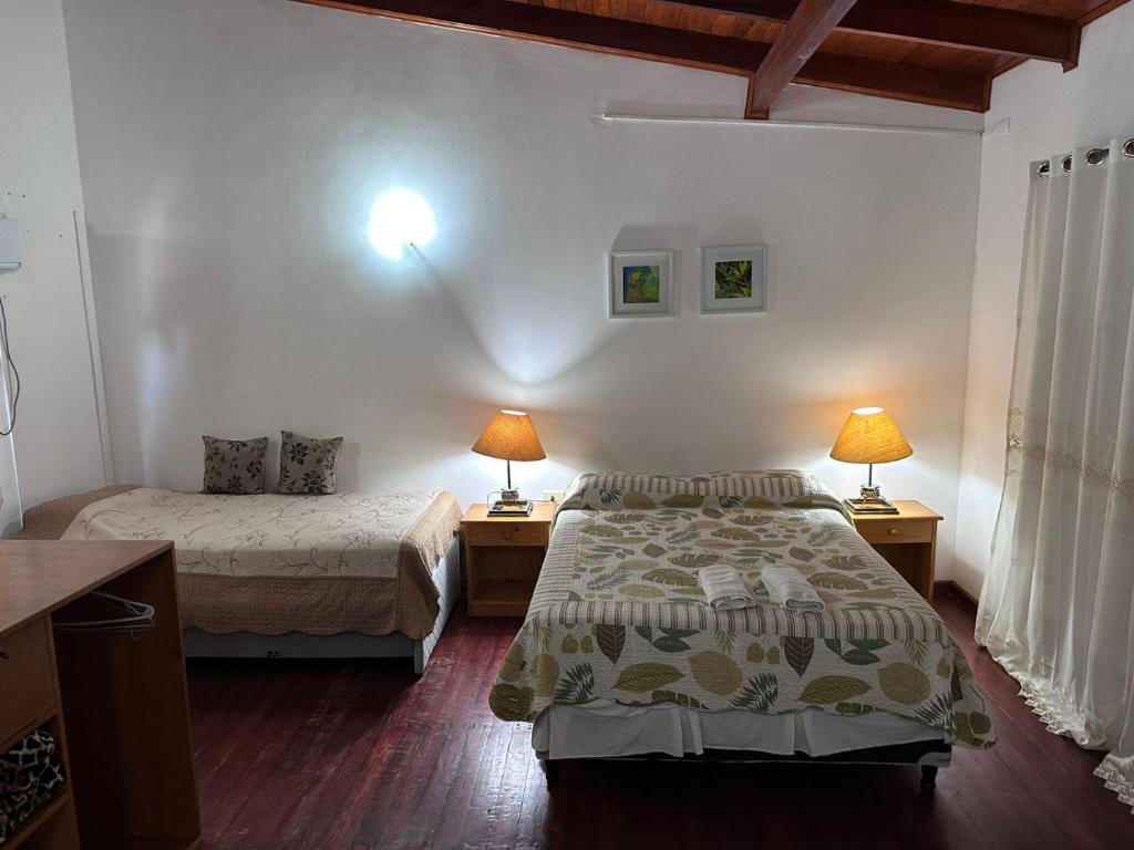 sypialnia z 2 łóżkami i 2 lampkami na stołach w obiekcie Reflejos de Luna Llena w mieście Puerto Iguazú