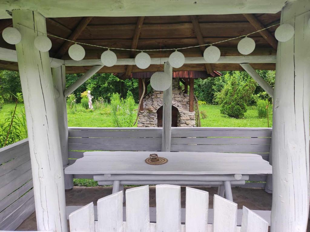 a white table and chairs in a gazebo at Agroturystyka Klimat in Bircza