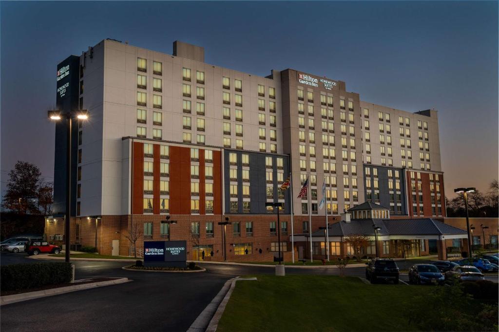 un gran edificio con coches estacionados en un estacionamiento en Homewood Suites by Hilton Baltimore - Arundel Mills en Hanover