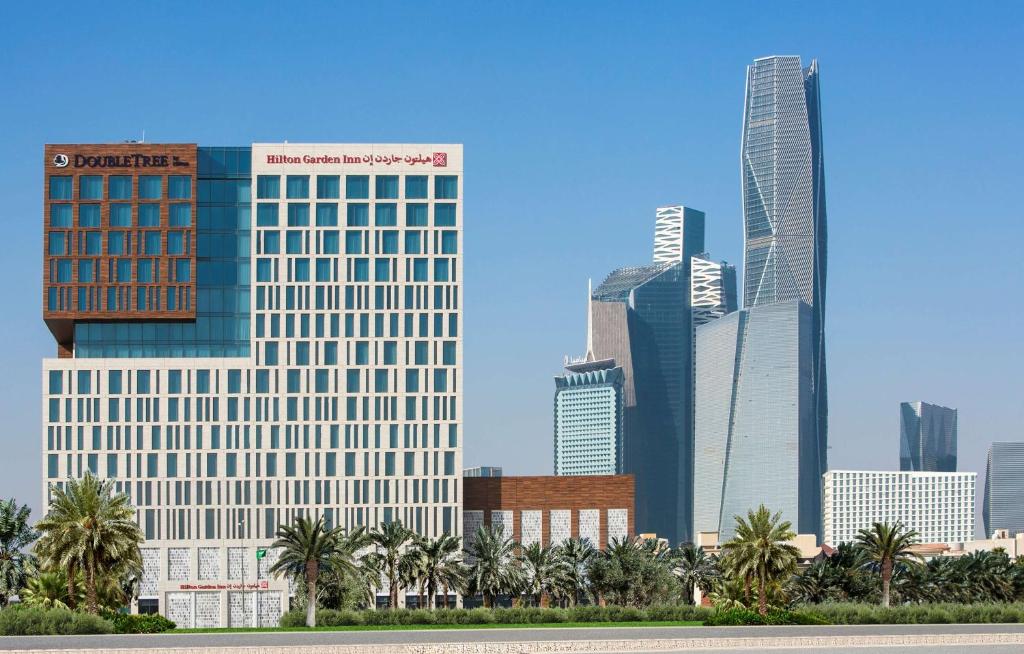 a city skyline with tall buildings and palm trees at Hilton Garden Inn Riyadh Financial District in Riyadh