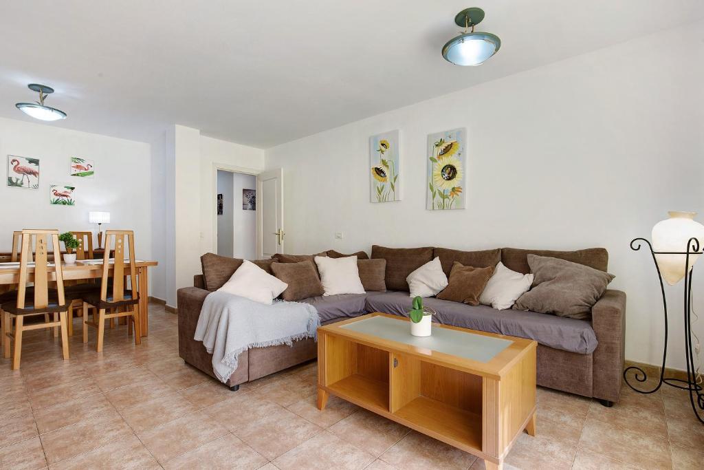 a living room with a couch and a table at Apartamento Las Palmeras in Gran Tarajal
