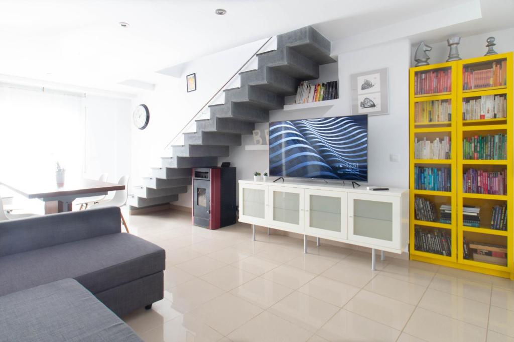a living room with a couch and a staircase at Sand Bay Beach Duplex in Girona