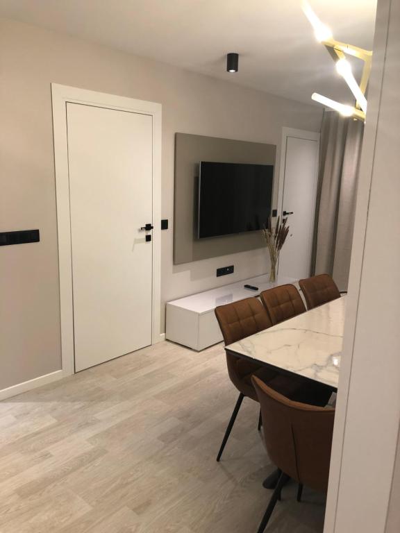 un salon avec une télévision, une table et des chaises dans l'établissement Lina, à Nice