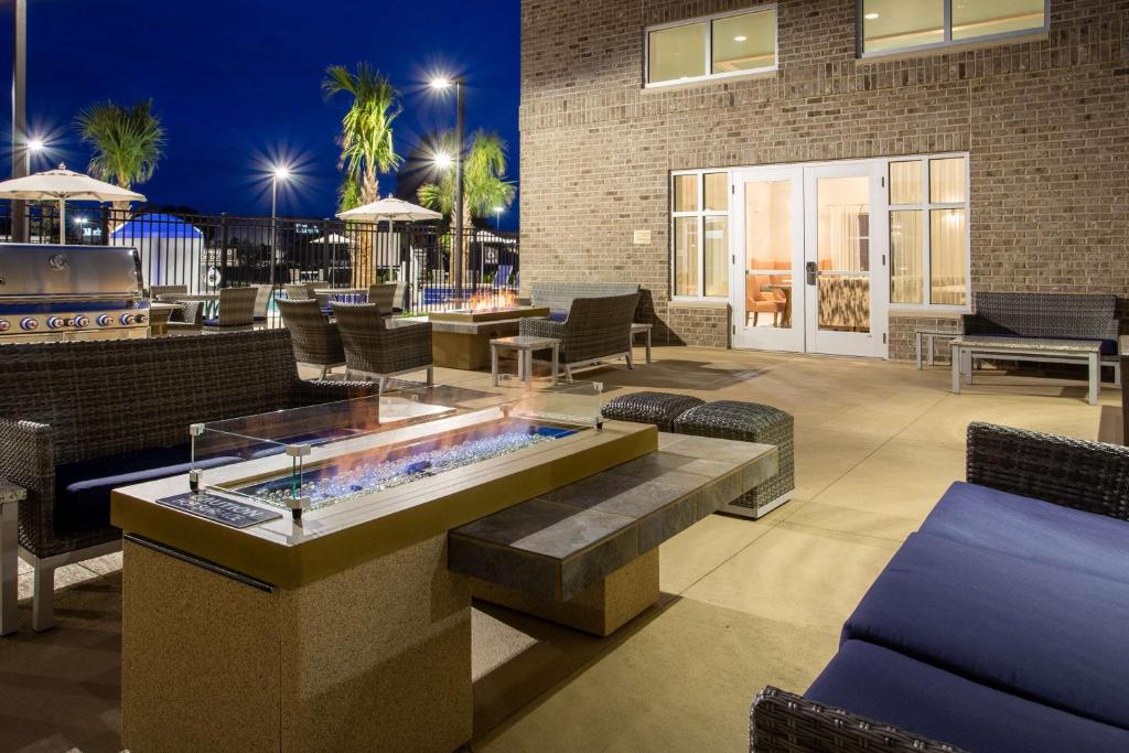 eine Terrasse mit einem Whirlpool sowie Tischen und Stühlen in der Unterkunft Homewood Suites By Hilton Myrtle Beach Coastal Grand Mall in Myrtle Beach