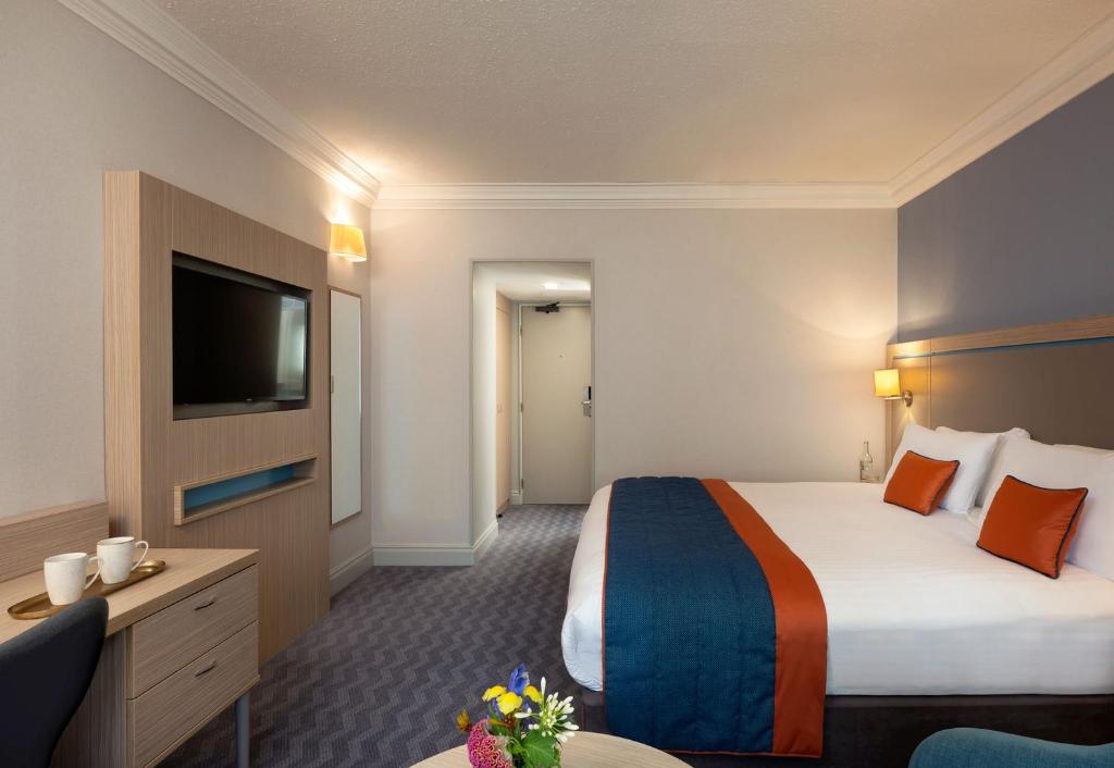 a hotel room with a bed and a flat screen tv at Leonardo Royal Hotel Brighton Waterfront in Brighton & Hove