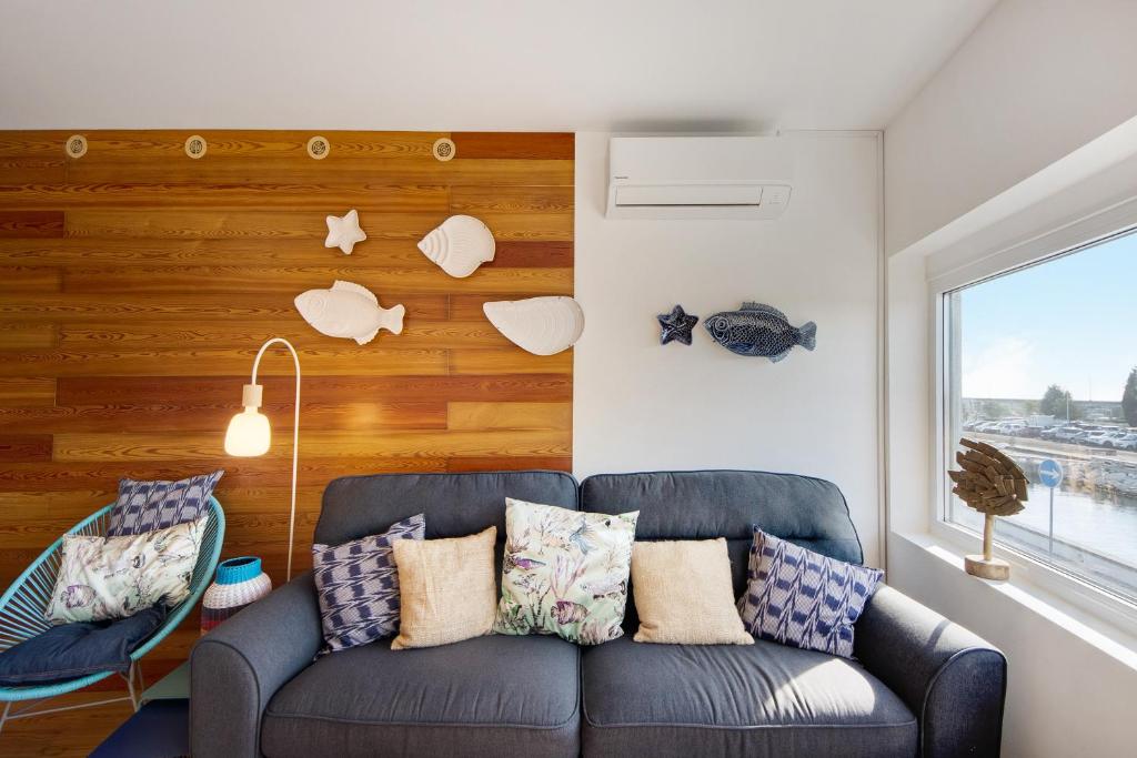 uma sala de estar com um sofá e uma parede de madeira em Apartamento T1 - Salina Ria em Aveiro