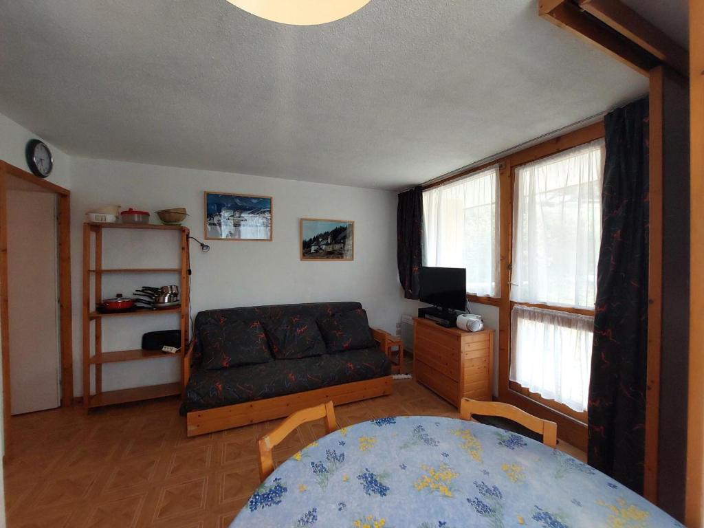 a living room with a couch and a table at Studio Peisey-Vallandry, 1 pièce, 4 personnes - FR-1-411-137 in Landry
