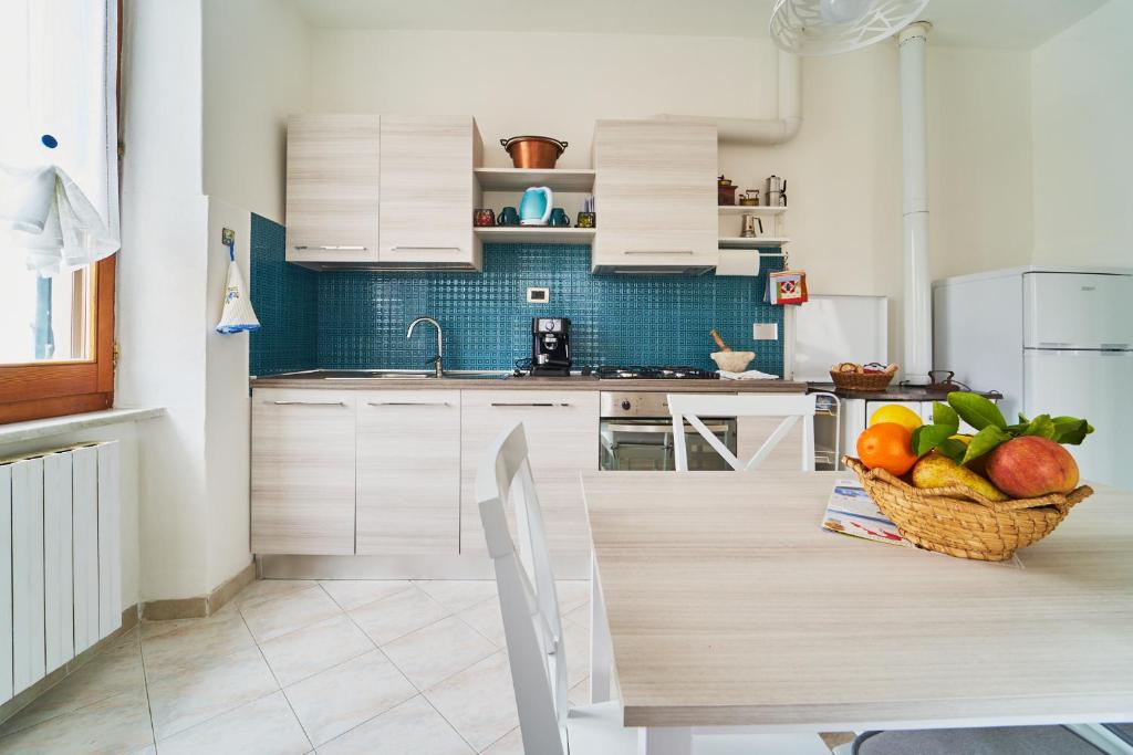 uma cozinha com uma mesa e uma cesta de frutas em Elysee em La Spezia